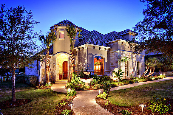 Front elevation with lighted landscaping and accents.